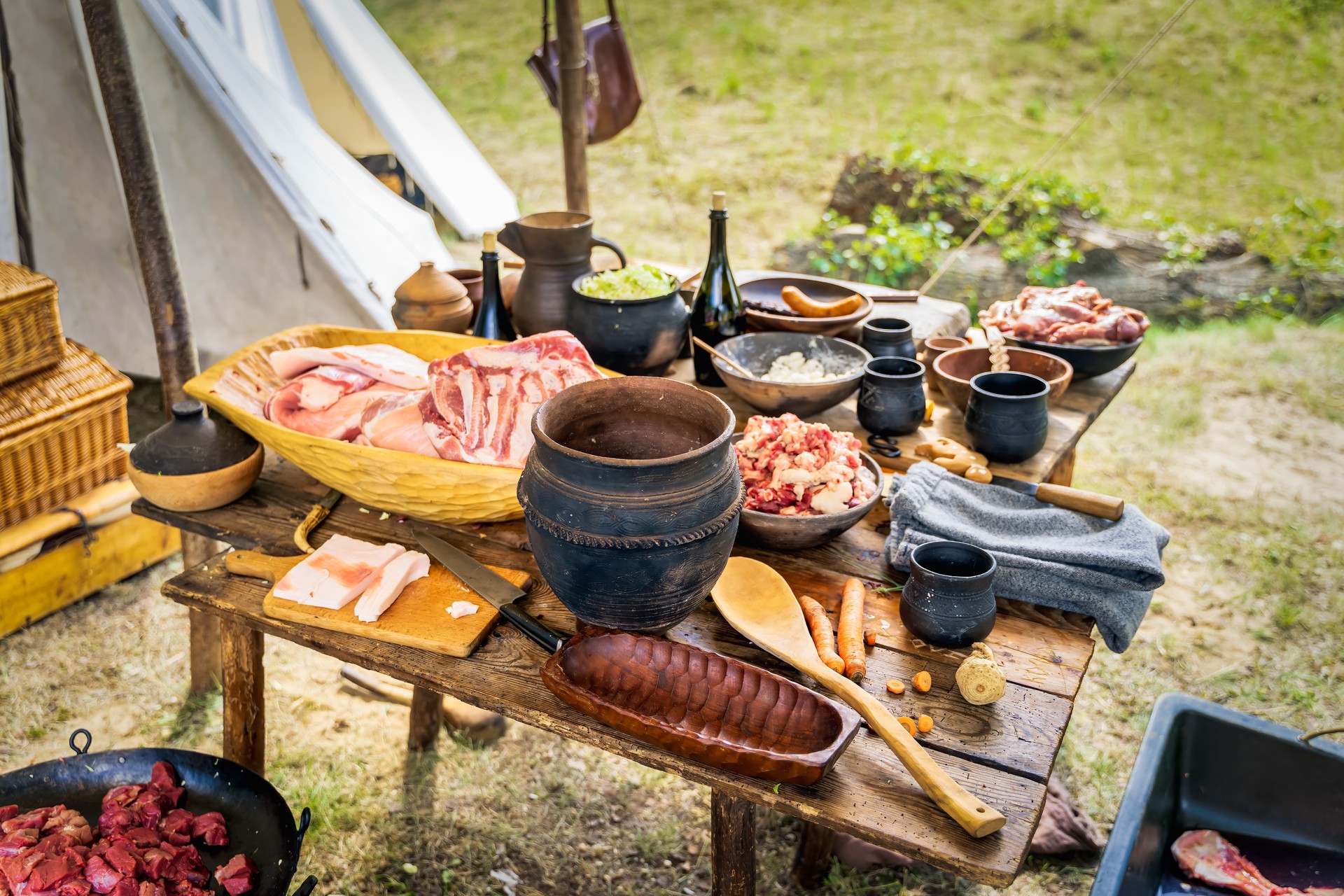 Chopped raw meat, homemade food and pottery on the table