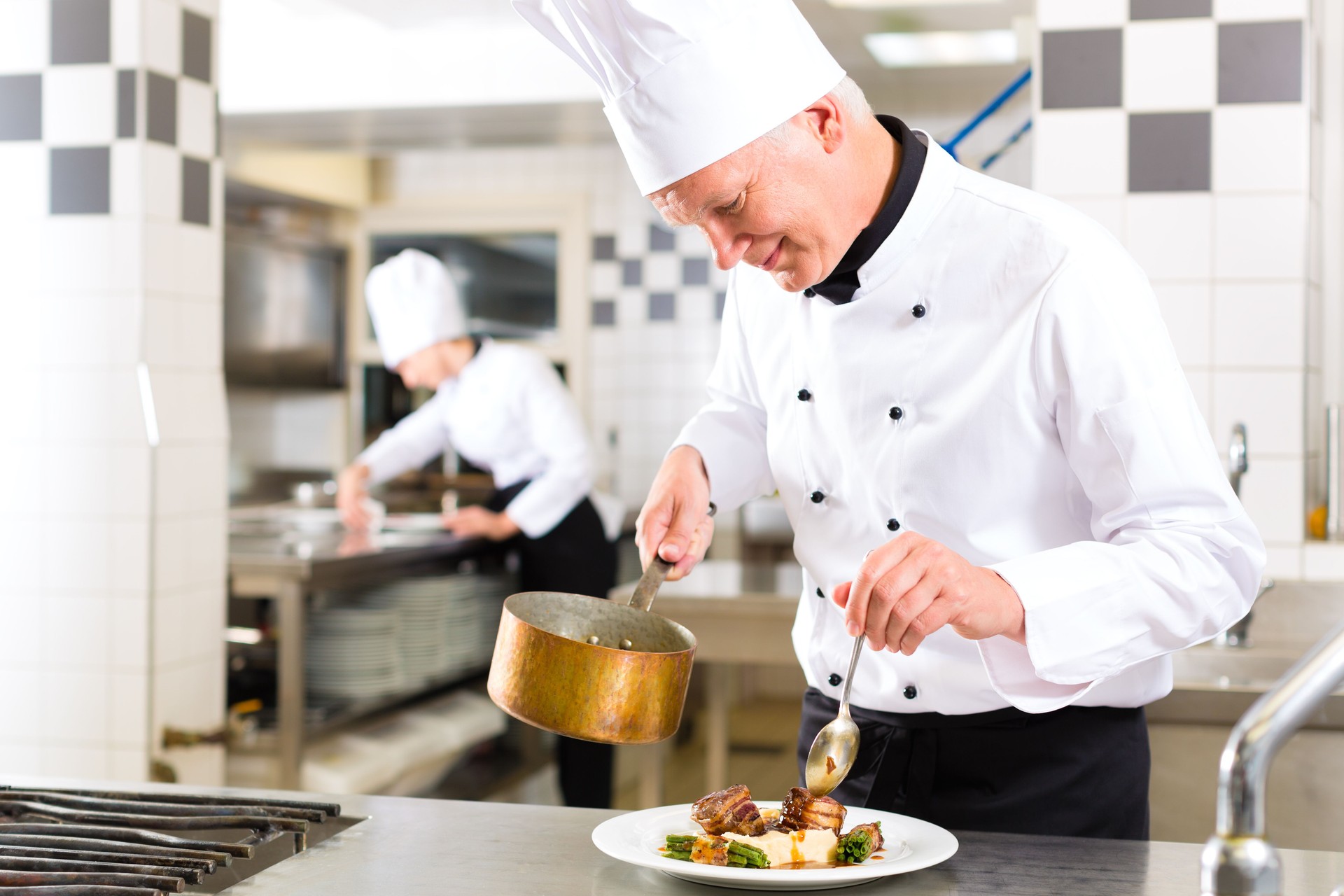 A chef preparing a dish in the kitchen